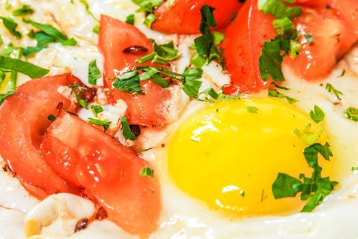 Fried eggs with tomato and herbs