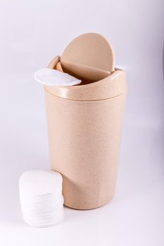 Plastic beige trash bin isolated on white background