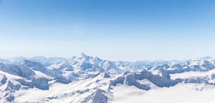 White snowy winter Caucasus mountains at sunny day. Panorama view from ski slope Elbrus, Russia with sky background