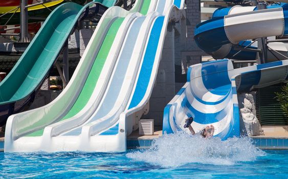 Colorful waterpark tubes and a swimming pool. Outdoor shot