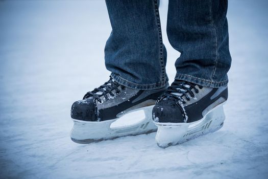 man wearing hockey skaters on ice rink