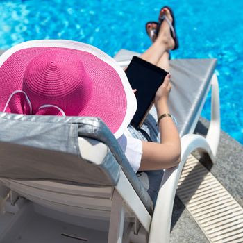 Woman on sunbed waering beautiful pink hat