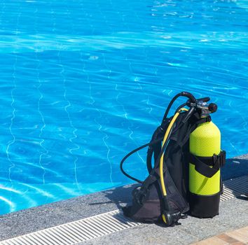 Set of scuba gear set up at the edge of a swimming pool