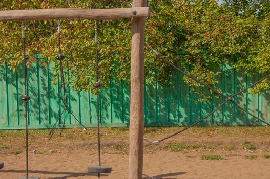 Empty old wood playground in summer day with rope