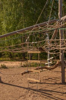 Empty old wood playground in summer day with rope