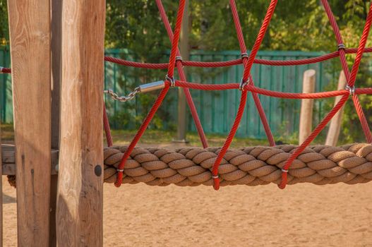 Empty old wood playground in summer day with rope