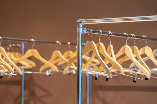 Wooden hangers on coat rack with no clothes in empty cloakroom