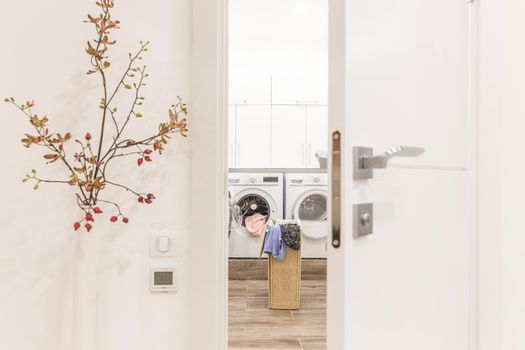 View through door to laundry room with basket and washing machine