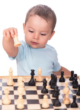 little boy staring at the chess pieces