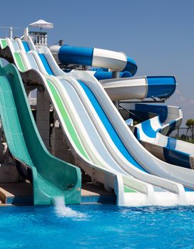 Colorful waterpark tubes and a swimming pool. Outdoor shot