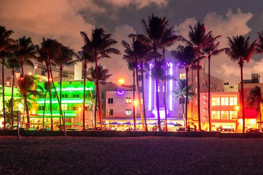 Miami Beach Ocean Drive hotels and restaurants at sunset. City skyline with palm trees at night. Art deco nightlife on the South beach