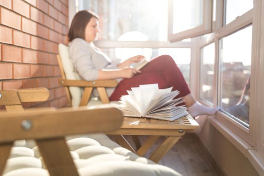 relaxed woman reading on balcony on a warm sunny day