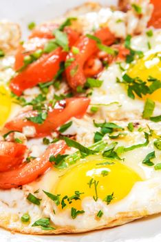 Fried eggs with tomato and herbs