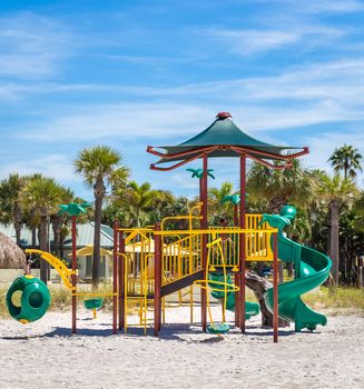 Children playground on the sunny beach with blue sky