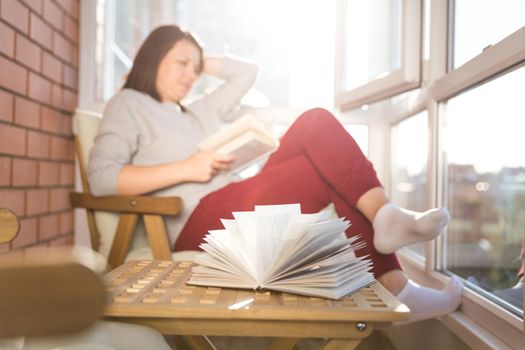 relaxed woman reading on balcony on a warm sunny day