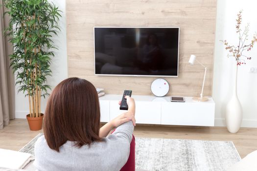 Young woman watching TV in the living room