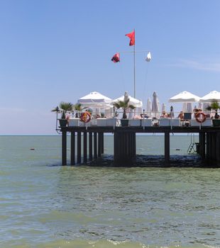 Pier on a sea with comfortable white armchairs