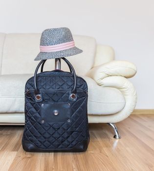 Suitcase and straw hat ready for travelling