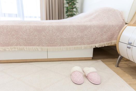 Bedroom in modern style with pink cozy soft slippers on floor