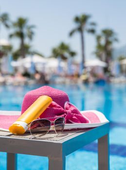 Nice pink hat with a bow near the pool