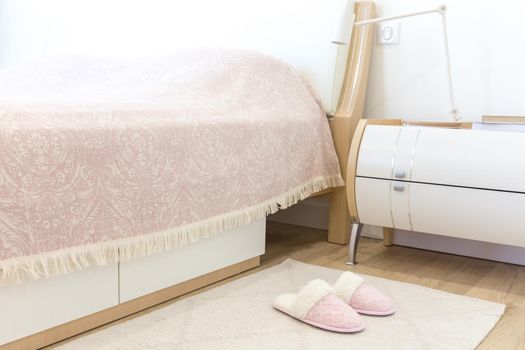Bedroom in modern style with pink cozy soft slippers on floor