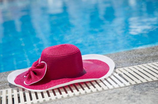 Nice pink hat with a bow near the pool