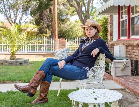 Country style portrait of a beautiful brunette young woman wearing a cowboy hat