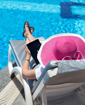 Woman on sunbed waering beautiful pink hat