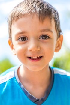Closeup portrait of a smiling boy against sun