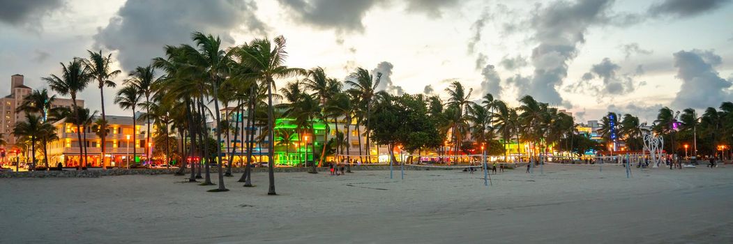 Miami Beach, USA - September 10, 2019: Ocean Drive hotels and restaurants at sunset. City skyline with palm trees at night. Art deco nightlife on the South beach