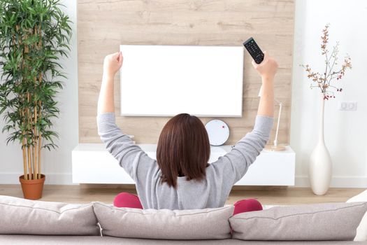 young happy woman watching alone excited television football sport match or TV contest