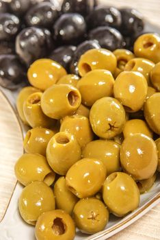 Pitted green and black olives on plate