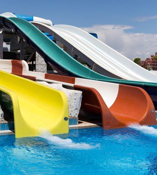 Colorful waterpark tubes and a swimming pool. Outdoor shot