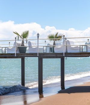 Pier on a sea with comfortable white armchairs