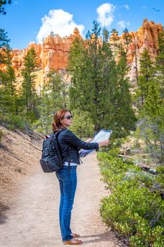 Girl searching right direction on map in Bryce Canyon, USA