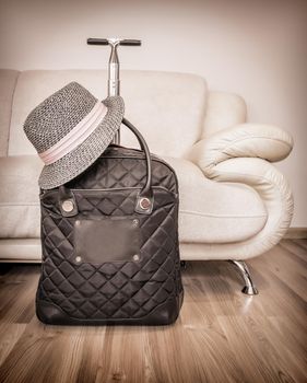 Suitcase and straw hat ready for travelling