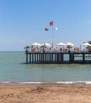 Pier on a sea with comfortable white armchairs