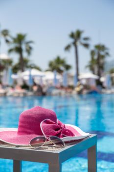 Nice pink hat with a bow near the pool