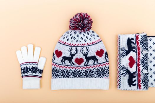 Gloves and woolen hat. winter set on orange background with copy space