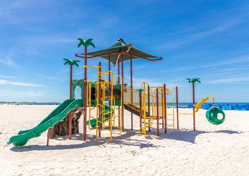 Children playground on the sunny beach with blue sky
