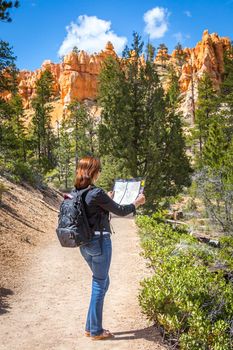 Girl searching right direction on map in Bryce Canyon, USA