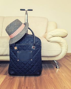 Suitcase and straw hat ready for travelling