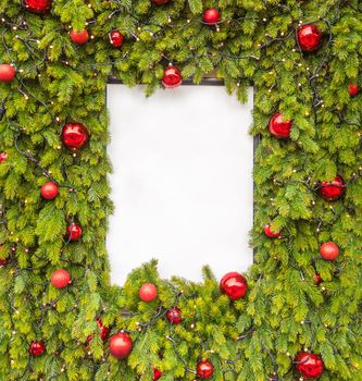 Creative layout made of Christmas tree branches with white paper card note. Flat lay with copy space. New Year concept.