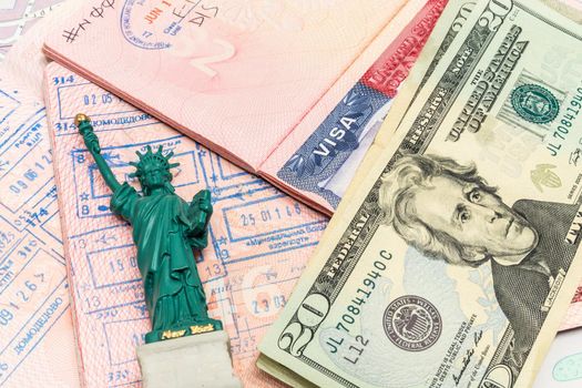 Passport, money and small statue of liberty