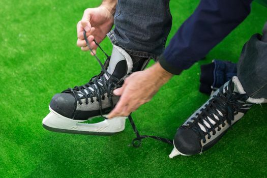 man sitting and preparing for ice skating