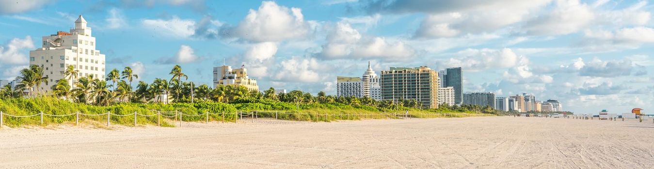 Art deco district of South Beach Miami. The buildings are painted in pastel colors surrounded by tropical palm trees.