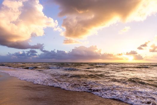 Cloud coastline background. Fiery orange sunset sky. Amazing sunrise on the beach in Miami.