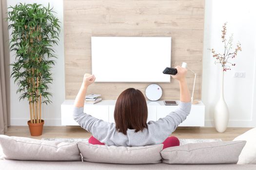 young happy woman watching alone excited television football sport match or TV contest