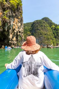 Waman wearing orange hat sailing in boat in Thailand