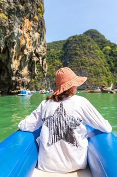 Waman wearing orange hat sailing in boat in Thailand